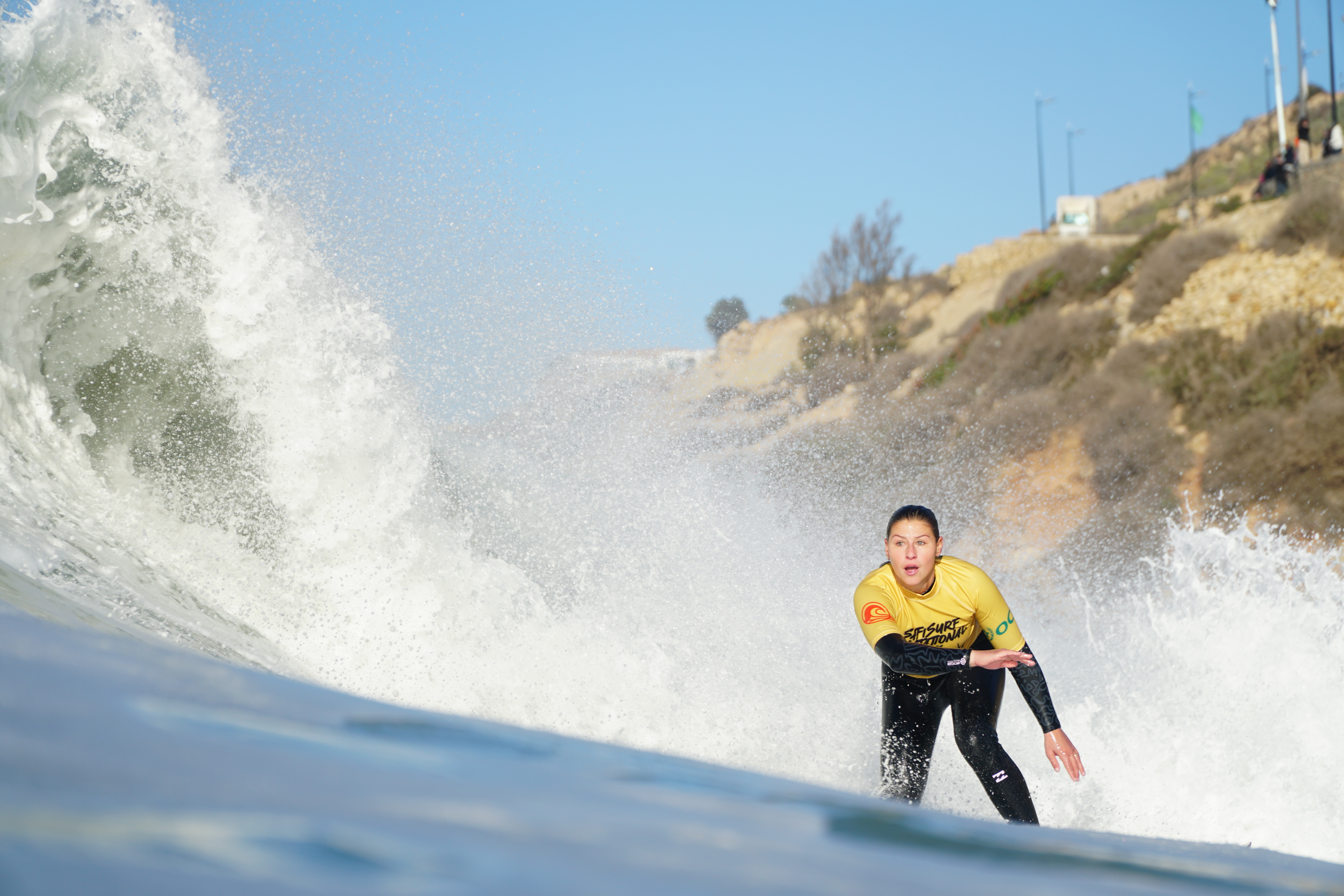 Surfer in yellow framed by the ocean